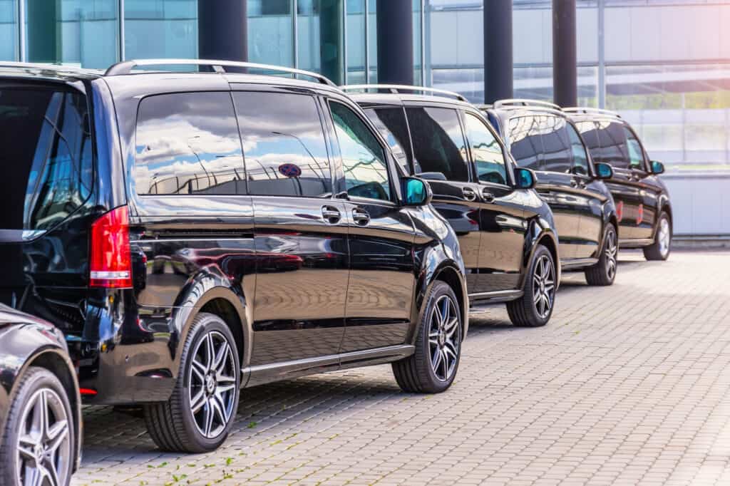 Elegant black chauffeur vans lined up for a special event in Ireland, offering premium group transportation services